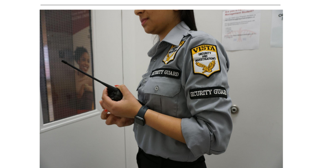Close-up of a Vista Security guard holding a walkie-talkie, with a focus on her Vista-branded shoulder badge.